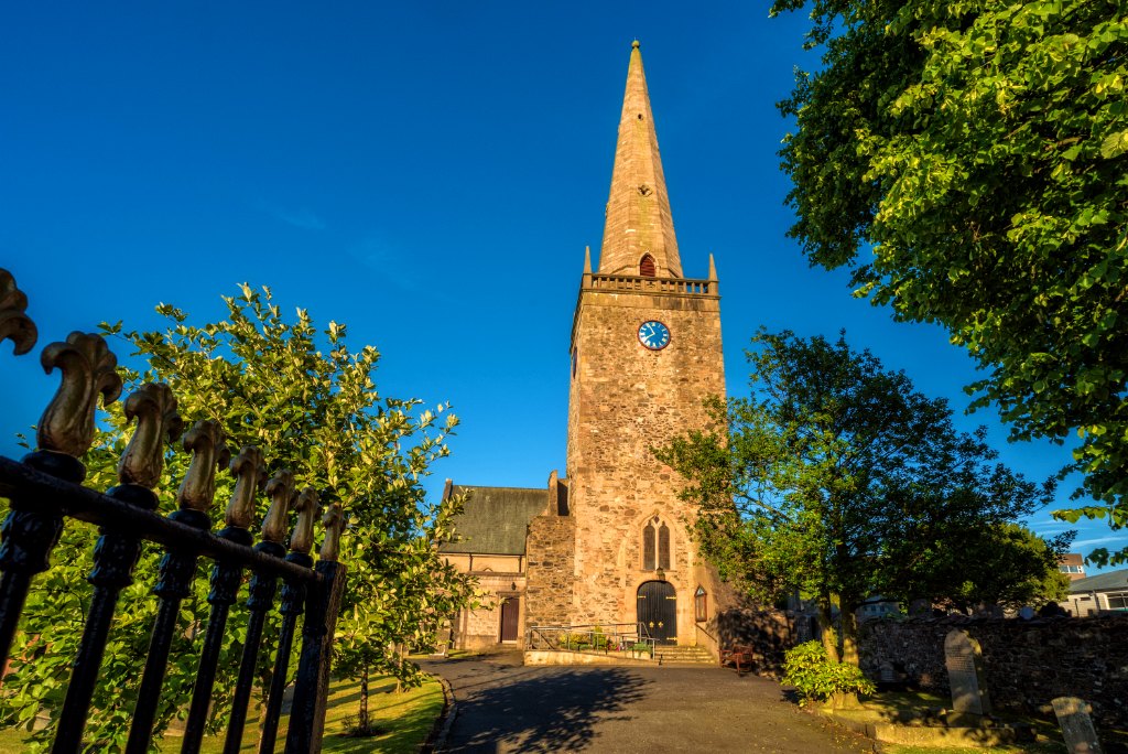 Bangor Abbey in warm evening light, showing the full stone tower and steeple